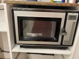a microwave sitting on top of a shelf in a kitchen