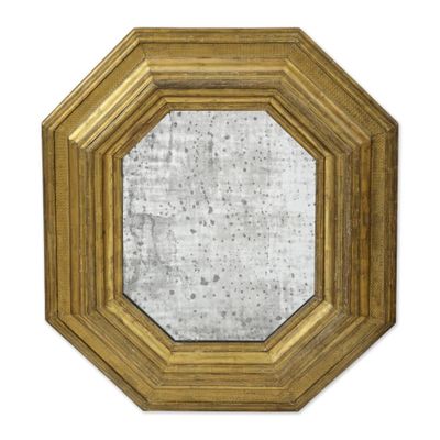 une image d'un miroir encadré d'or sur un mur blanc