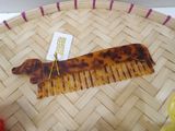 a tortoise shaped comb with a tag on it