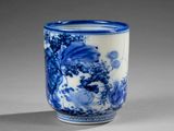 a blue and white cup with a floral design on it