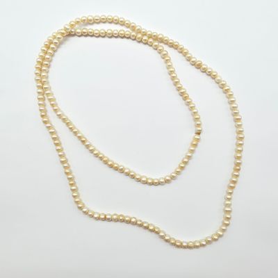 un collier de perles blanches avec un fermoir en or