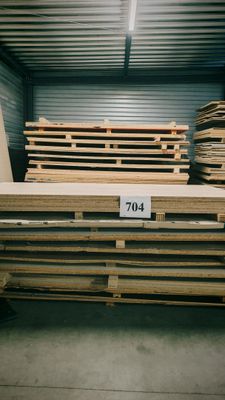 une grande pile de palettes en bois dans un entrepôt, avec une étiquette de prix