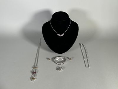 a necklace, bracelet, and ring on display on a table
