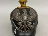 un vieux casque noir et doré orné d'un aigle