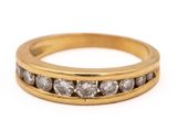 a close up of a yellow gold ring with three rows of diamonds