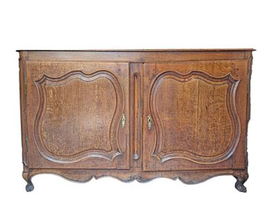 Buffet en chêne mouluré et sculpté ouvrant par deux portes. …
