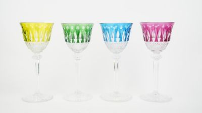 four different colored wine glasses are lined up in a row