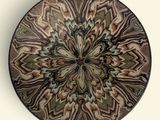 a brown and black plate with a pattern on it