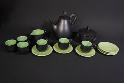 many cups and saucers sitting on a black table