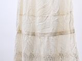 a white skirt hanging on a hanger against a white wall