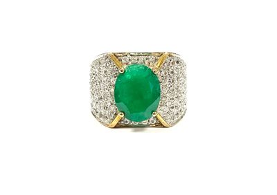 a close up of a ring with a green stone in it