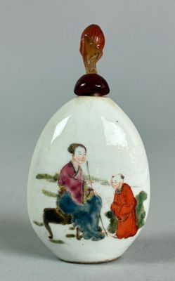 a white egg with a picture of a woman and a man sitting on a bench