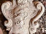 une plaque en pierre représentant un lion, posée au sol