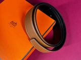a close up of a belt on a pink surface with a box