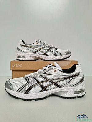 a pair of white and black running shoes on a box