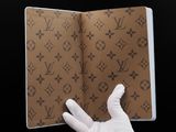 someone in white gloves is holding a brown book with a pattern on it