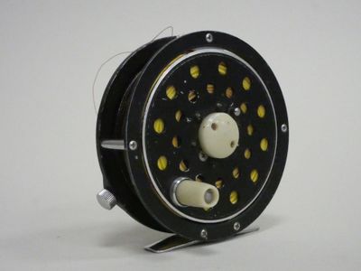 a close up of a fishing reel on a white surface