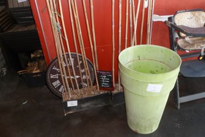 un seau vert posé à côté d'un tas de brindilles