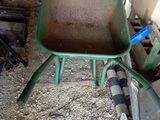 une brouette verte au milieu d'un tas de terre