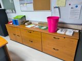 a pink trash can sitting on top of a wooden dresser
