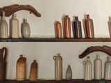 de nombreuses bouteilles et vases sur les étagères de la pièce