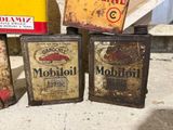 three old tin cans sitting on top of a cement floor next to each other