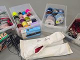 many different types of thread and scissors on the table