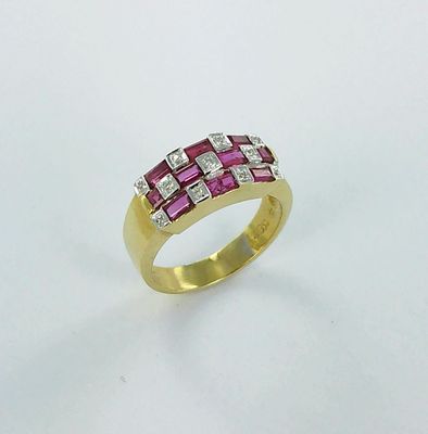 gros plan d'une bague en or avec des pierres roses et blanches