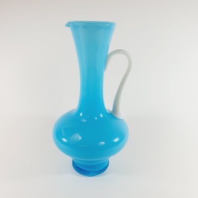 blue glass vase with a white handle on a white background