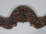 an ornately carved wooden door handle on a white wall