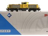 La boîte est ouverte, laissant apparaître un train jaune sur fond blanc.
