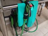 un tuyau vert relié à un sac bleu posé par terre