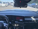 dashboard of a car with a view of a parking lot with cars in the background