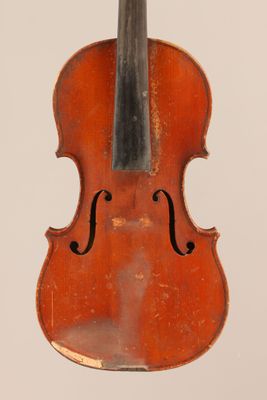 un vieux violon posé sur une surface blanche