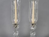 pair of clear glass candlestick holders with gold accents on each of them