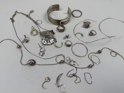 a lot of silver jewelry on a white surface