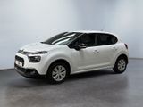 une voiture blanche de marque Citrole garée dans une pièce blanche