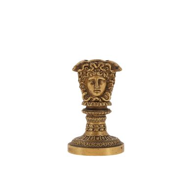 une statue en or représentant une tête coiffée d'une couronne