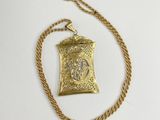 a gold necklace with a small pendant on a gold chain