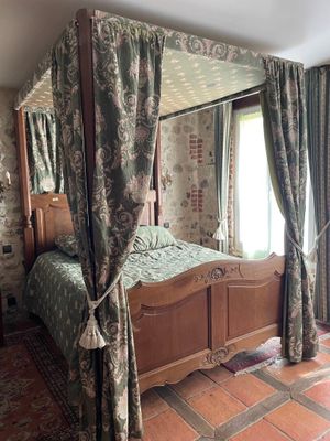 a bed with a canopy in a room with a tiled floor