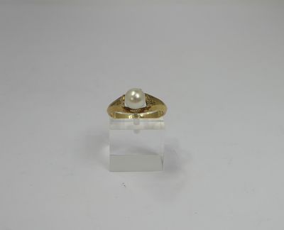 a close up of a gold ring with a pearl on it