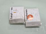 two boxes of earphones sitting on top of a white table