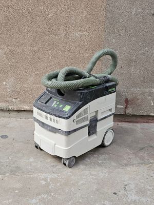 un aspirateur posé par terre, muni d'un tuyau