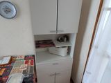 une petite cuisine équipée d'une table et de placards