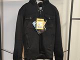 une veste noire accrochée à un portant dans un magasin