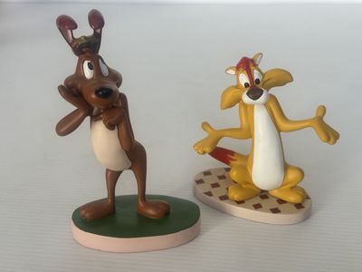 deux figurines représentant un chien et un chat posées sur une table
