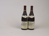 deux bouteilles de vin posées l'une à côté de l'autre sur une surface blanche