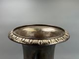 a silver vase that is sitting on a table