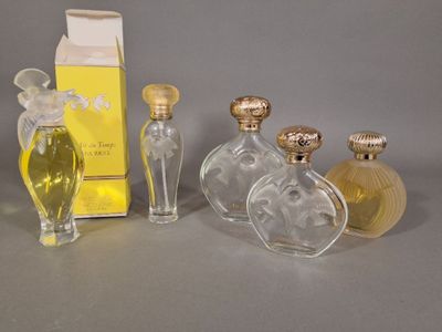 trois flacons de parfum posés l'un à côté de l'autre sur une table