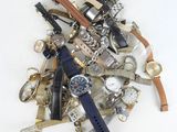 a pile of assorted watches and watches on a white surface